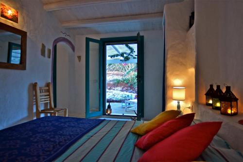 sypialnia z łóżkiem z czerwonymi poduszkami i oknem w obiekcie Casa Simonetta w mieście Carloforte