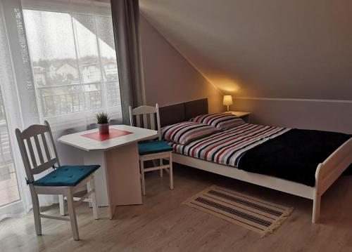 1 dormitorio con 1 cama, mesa y sillas en Pokoje gościnne KOTWICA en Władysławowo
