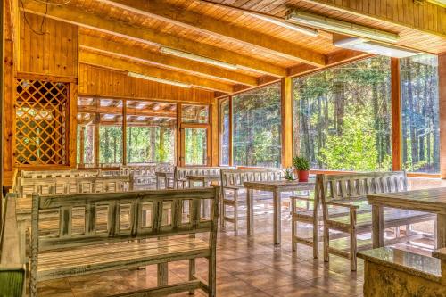 a dining room with wooden tables and chairs at Крушун - Единствена на метри от водопадите, Krushun - The only stay just meters from the waterfalls in Krushuna