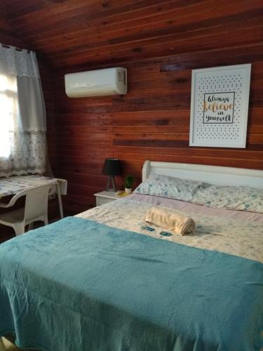 um quarto com uma cama com uma toalha em Chalé suíte com ar em Resende em Resende