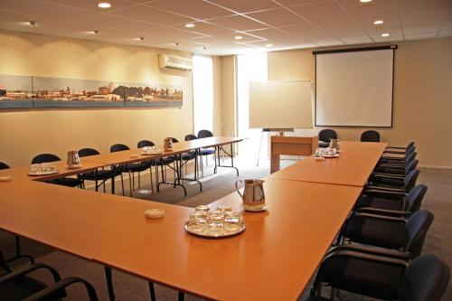 a conference room with tables and chairs and a whiteboard at Harbour City Motor Inn & Conference in Tauranga