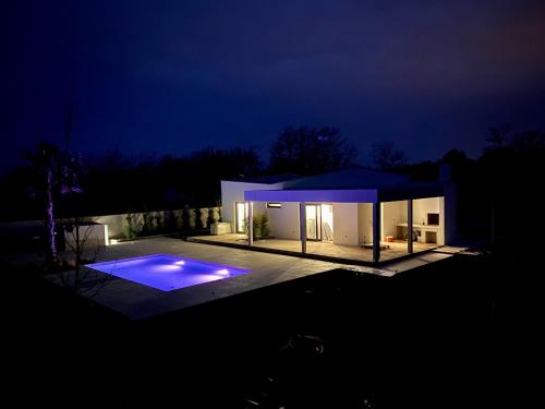a house lit up at night with a swimming pool at Villa Eni Medulin Sisan heated pool in Šišan
