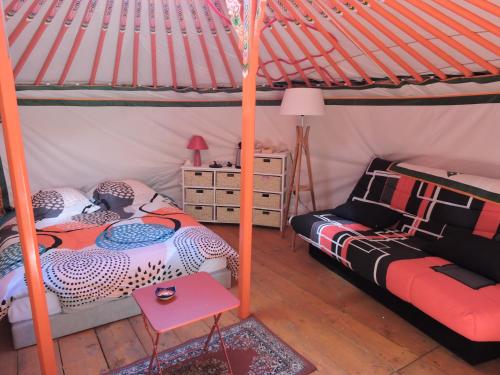 1 Schlafzimmer mit 2 Betten und einem Tisch in der Unterkunft Yourte mongole in Mont-Roc