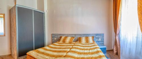 a bedroom with a bed with a blanket on it at Крушун - Единствена на метри от водопадите, Krushun - The only stay just meters from the waterfalls in Krushuna