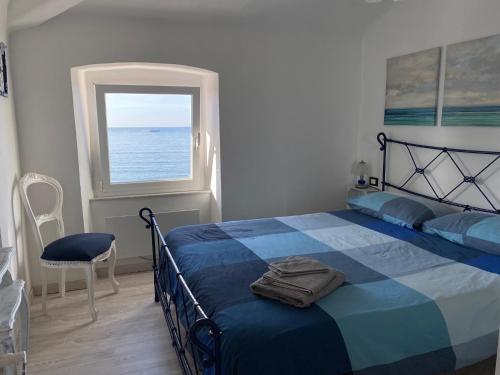 una camera con un letto blu e una finestra di La Casetta di Dory sul Mare a Genova