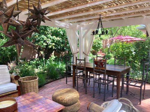 an outdoor patio with a wooden table and chairs at Casa Culinaria - The Gourmet Inn in Santa Fe