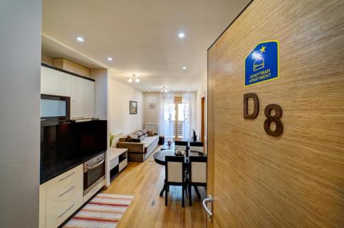 een keuken en eetkamer met een bordje op een deur bij Apartman Dragisic Kalman J15,D8 in Zlatibor