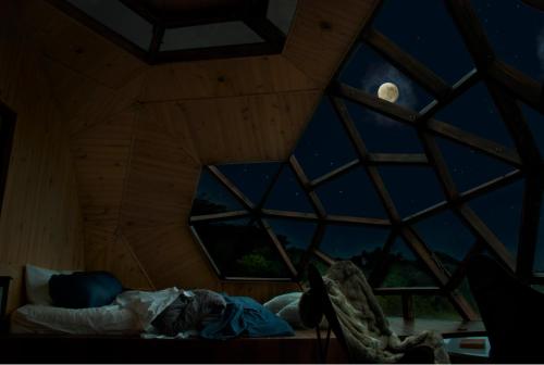a room with a large window with a full moon at Nacimiento Glamping in San Agustín