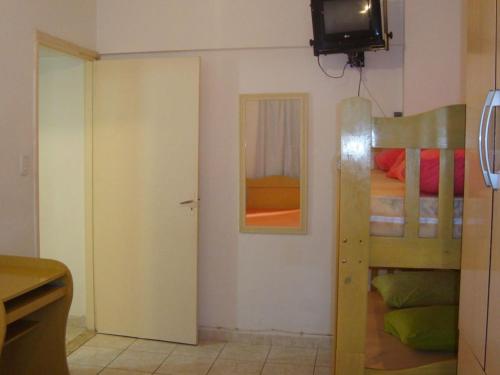 ein kleines Zimmer mit einem Etagenbett und einem Fernseher in der Unterkunft APARTAMENTO EM SÃO VICENTE - SP in São Vicente