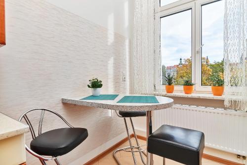 stół i 2 krzesła w pokoju z oknem w obiekcie Apartament Nowa 12 we Wrocławiu