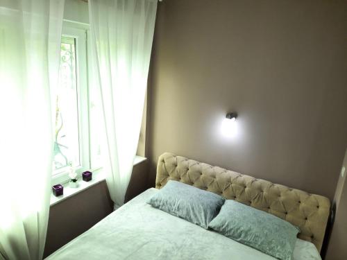 a bedroom with a large bed with a window at Apartman Nana in Mostar