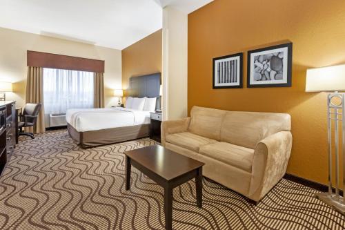 a hotel room with a couch and a bed at La Quinta by Wyndham South Bend in South Bend