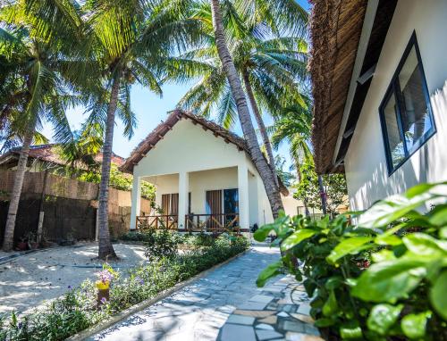 a house with palm trees and a walkway at Paradise Resort Doc Let - All Inclusive in Doc Let