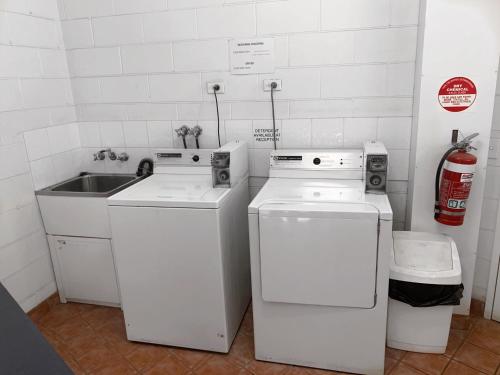 a kitchen with two washing machines and a sink at Boulevard Lodge Bundaberg in Bundaberg