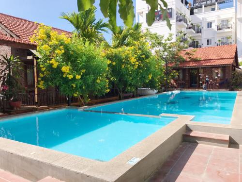 a large blue swimming pool next to a building at MAY Bungalow in Mui Ne
