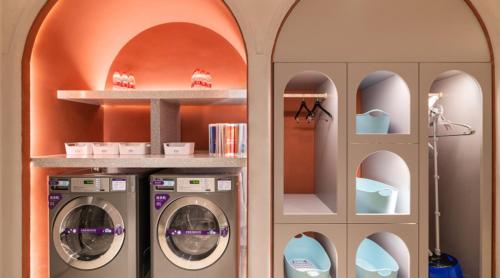 a laundry room with two washing machines and shelves at Mercure Beijing Zhongguancun in Beijing