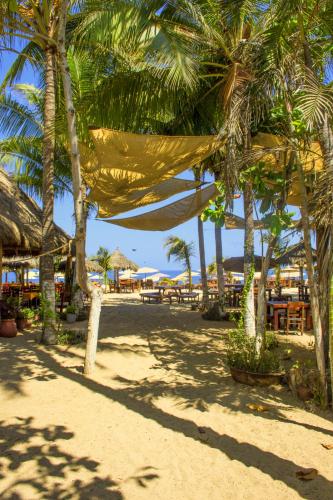 a beach with palm trees and a hammock on it at Galería Suites San Pancho in San Francisco