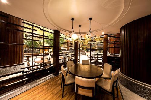 a dining room with a table and chairs and books at Howard Johnson Neodalle Resort Zhangjiajie in Zhangjiajie