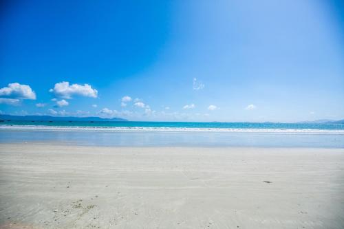 a sandy beach with the ocean in the background at Paradise Resort Doc Let - All Inclusive in Doc Let