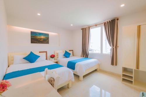 a hotel room with two beds and a tv at Thanh Thanh Hotel in Da Lat