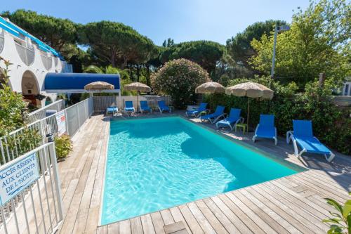 una piscina con sedie e ombrelloni su una terrazza di legno di Hotel Europe a La Grande-Motte