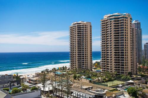 two tall buildings next to the beach and the ocean at Paradise Centre Apartments managed by GCHS in Gold Coast