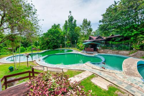 a swimming pool in a yard with a wooden deck at Sutera Sanctuary Lodges At Poring Hot Springs in Ranau