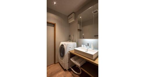 a bathroom with a washing machine and a sink at Hikoso-machi Kin no Ma in Kanazawa