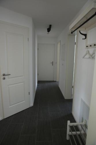 an empty hallway with a white door and a floor at Apartment Seeglück am Schliersee - modern, zentral, perfekt für Familien in Schliersee