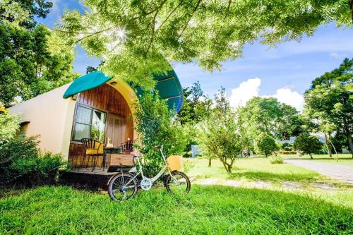 a tiny house with a bike parked in the grass at Ville Greensward in Taitung City