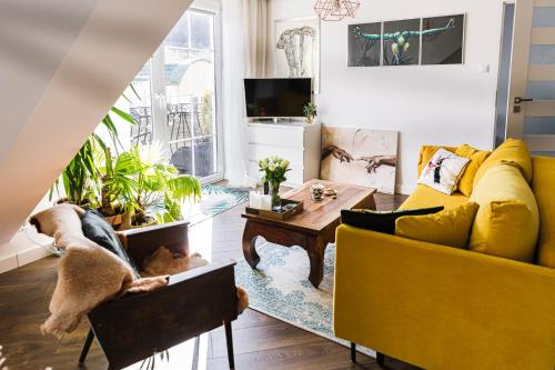 a living room with a yellow couch and a table at Apartament Dobre Miejsce in Ustrzyki Dolne