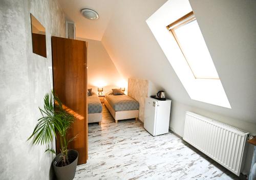 a attic room with a skylight and a bedroom at Penzion Pri Parku in Trenčín