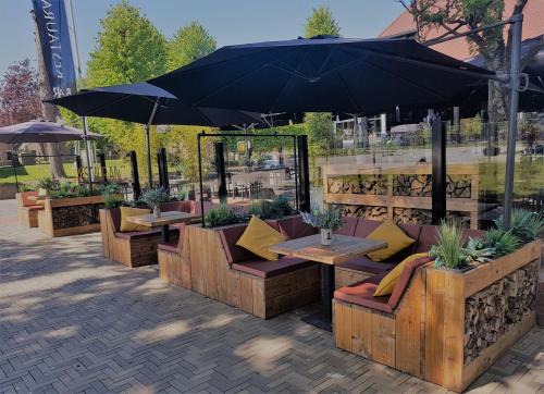 a patio with tables and chairs under an umbrella at Hotel Bieze in Borger