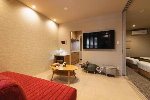 a living room with a red couch and a table at GRAND BASE Crane in Fukuoka