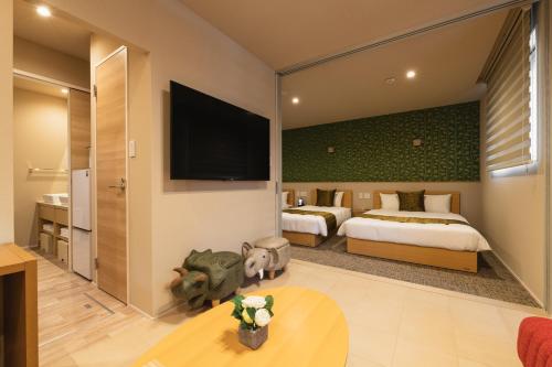 a hotel room with two beds and a flat screen tv at GRAND BASE Crane in Fukuoka