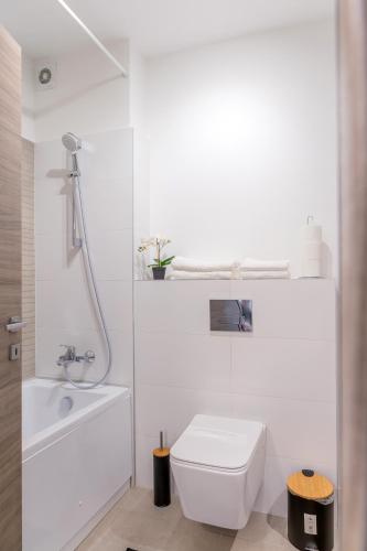 a white bathroom with a toilet and a sink at ATLAS UNIRII: Upscale Flats in the Heart of Bucharest! in Bucharest