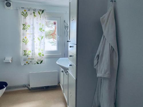 uma casa de banho com uma porta com um lavatório e uma janela em Stuga Holmasjön em Vetlanda
