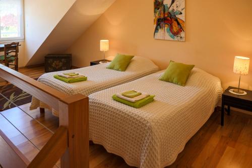 - une chambre avec 2 lits et des serviettes vertes dans l'établissement Pré en Bulles, à Trépail