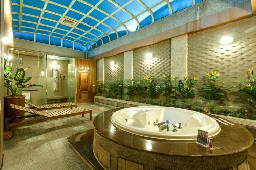 基隆的住宿－北極星經典汽車旅館，带浴缸和植物的大浴室
