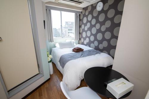 a small room with two beds and a table at Vail sta Takenotsuka in Tokyo