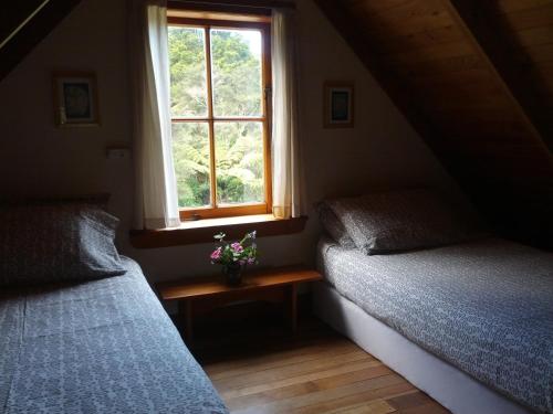2 camas en una habitación con ventana en The Innlet, Country Apartments and Cottages, en Collingwood