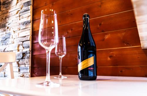 a bottle of wine and two glasses on a table at Penzion Kera in Rossitz