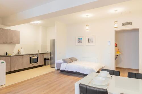a kitchen and living room with a bed and a table at ATLAS UNIRII: Upscale Flats in the Heart of Bucharest! in Bucharest