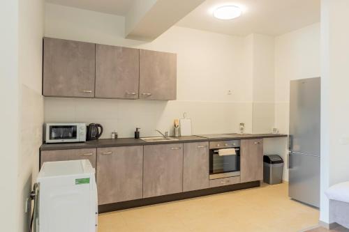 a kitchen with stainless steel cabinets and a microwave at ATLAS UNIRII: Upscale Flats in the Heart of Bucharest! in Bucharest