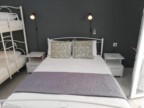 a bedroom with a white bed and two bunk beds at Marianna Studios in Aghios Petros Alonissos