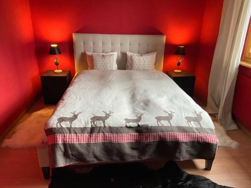 ein rotes Schlafzimmer mit einem Bett mit vier Hirschen drauf in der Unterkunft Ferienwohnung Sunneschii in Davos