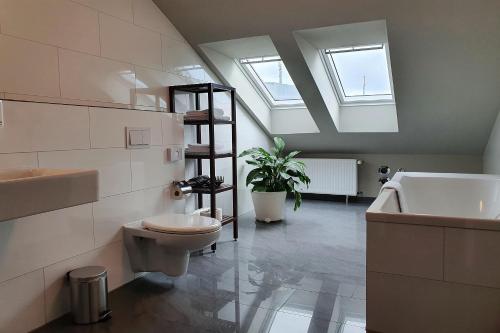 uma casa de banho com um WC, um lavatório e uma clarabóia em Aparthotel Mitte em Dresden