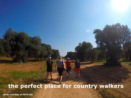 a group of people walking down a dirt road at B&B Villa Giuliana in Arnesano