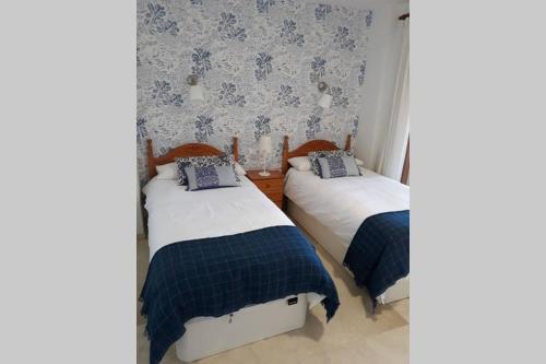 - 2 lits dans une chambre avec papier peint bleu et blanc dans l'établissement El Centro 15 (Verblijf aan de Costa), à Benidorm
