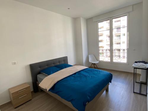 a bedroom with a blue bed and a window at 219 Promenade in Nice